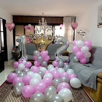 סידור בלונים לבת מצווה בבית, ספרות כסופות על עמודים, כתר זהב ובלון שקוף בהדפסה אישית, אותיות HAPPY BIRTHDAY ומצע בלונים על הרצפה, המשלוח כולל עיצוב במקום.