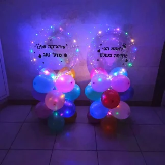 הפתעה אישית ומיוחדת שמתאימה לכל גיל, זוג מעמדי בלונים מוארים עם בלון בובו שקוף בהדפסה אישית, מגיע מעל המעמדים של 4 קומות מבלונים בצבעים לבחירה.